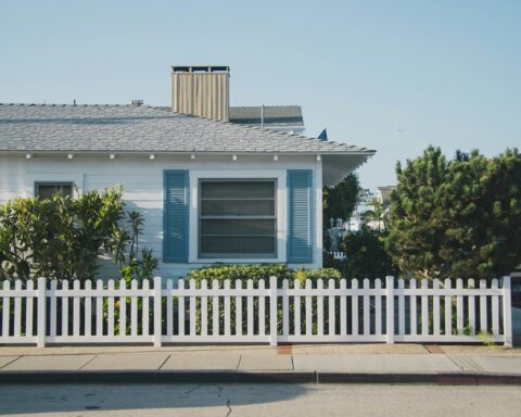 Neritic - A light, coastal-inspired living room featuring natural wood textures, soft blue accents, woven décor, and ocean-influenced artwork.