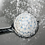 Black shower head running water safely during a boil water notice