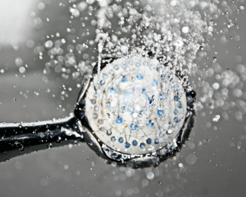 Black shower head running water safely during a boil water notice