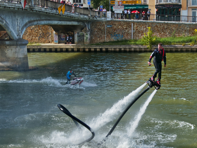 A water skier cuts across the surface, pulled by a boat—an everyday moment within river sports culture where balance, speed, and connection to water intersect. Photograph by Pascal Bernardon.