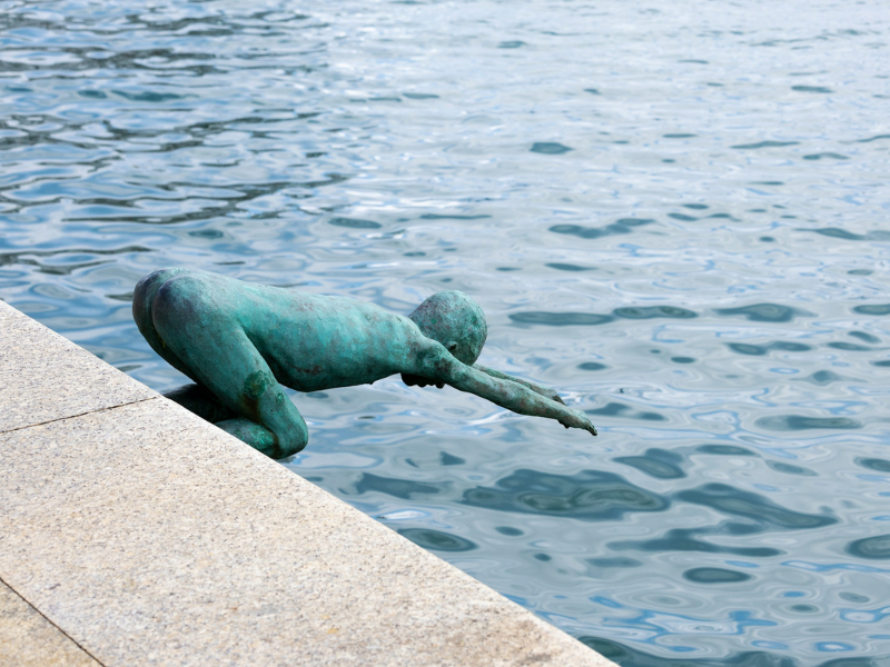 A statue of a person diving into a body of water - Contemporary Art