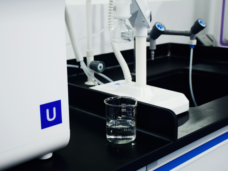 clear glass mug beside white and blue electric toothbrush representing spring water vs. purified water in everyday hygiene and daily routines