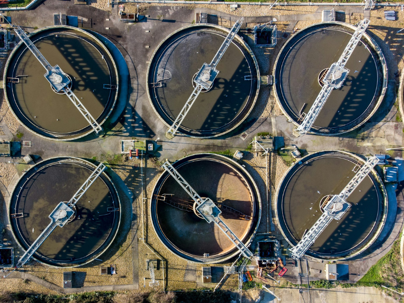 a large group of water tanks sitting next to each other representing storage and infrastructure in the comparison of spring water vs. purified water systems