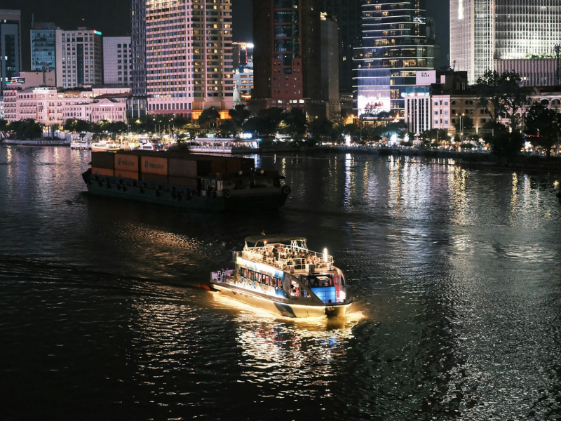 Themed river cruises sailing at night with boats on a river surrounded by glowing city lights, creating a vibrant evening cruise atmosphere.