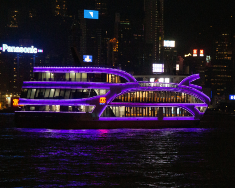 Lighted river cruise sailing at night with city lights reflecting on the water, illustrating the nighttime experience of river cruises.