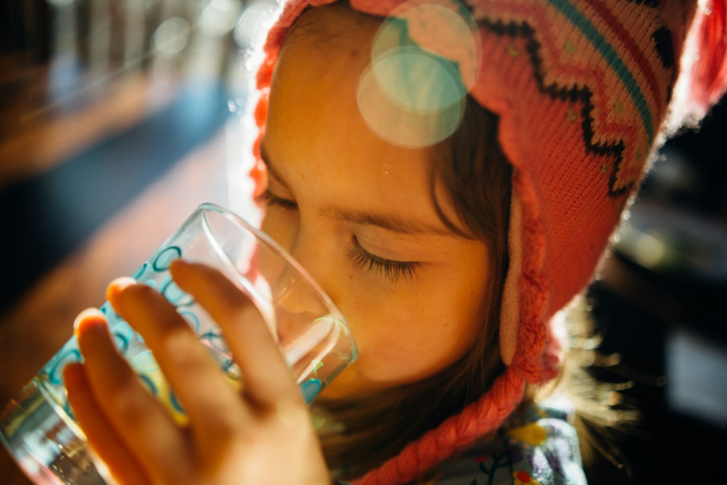 How Long Can You Survive Without Water? A girl drinking water from a bottle to stay hydrated.