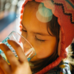 How Long Can You Survive Without Water? A girl drinking water from a bottle to stay hydrated.