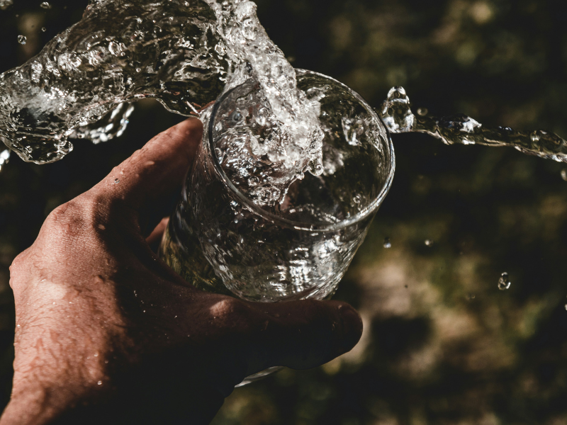 How Long Can You Survive Without Water? A person holding a drinking glass filled with water, highlighting the importance of daily hydration.