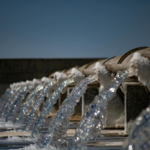 Water reuse facility with treated water flowing from multiple discharge pipes, illustrating wastewater recycling and sustainable water management.