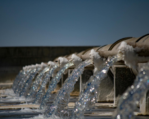 Water reuse facility with treated water flowing from multiple discharge pipes, illustrating wastewater recycling and sustainable water management.