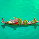 Floating markets in Bangladesh where a boat vendor transports fresh produce, highlighting traditional water-based trade and community livelihoods.