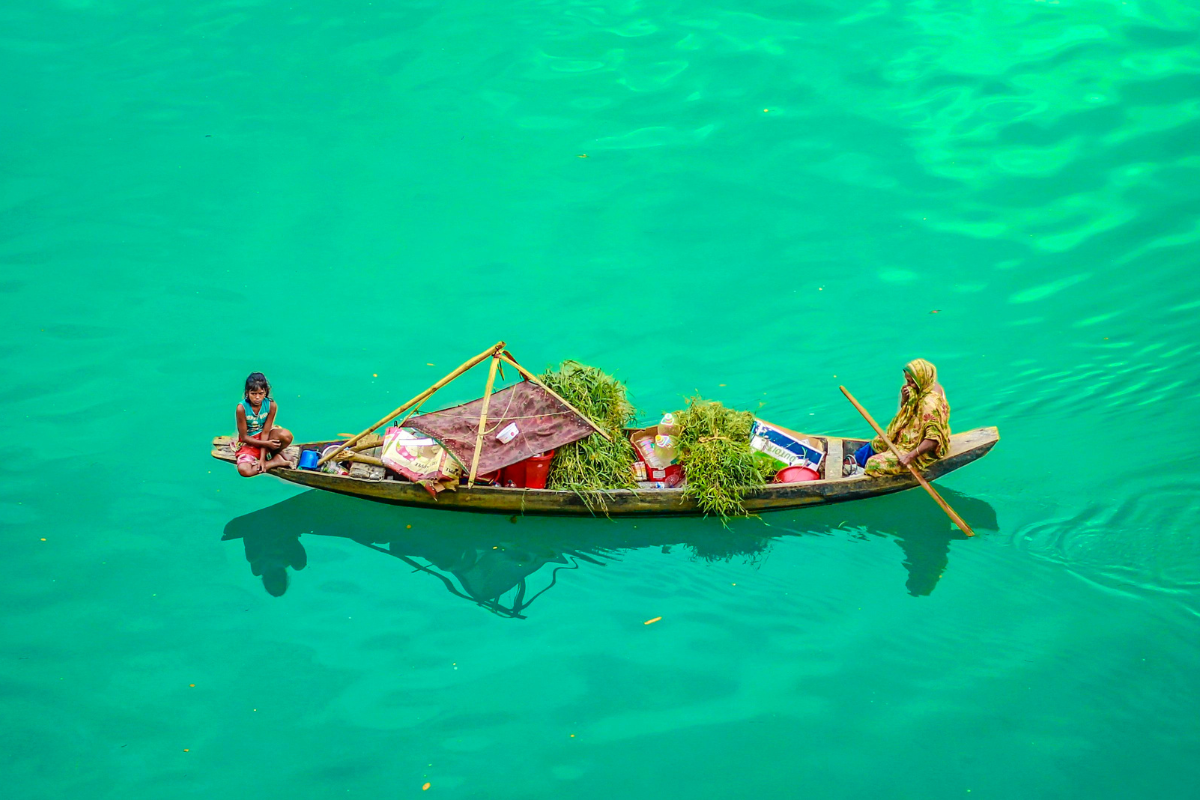 Floating markets in Bangladesh where a boat vendor transports fresh produce, highlighting traditional water-based trade and community livelihoods.