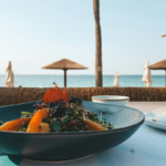A fresh food dish served beside the coast, highlighting the connection between water, food and coastal landscapes.