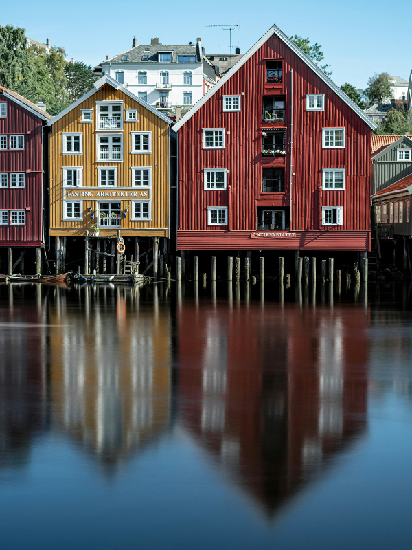 Colorful wooden stilt houses rise above the waterfront, showing how architecture can adapt closely to life at the water’s edge.