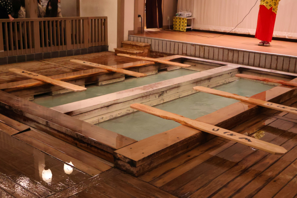 Traditional Japanese public bathhouses with wooden bathing pools filled with hot water.