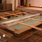 Traditional Japanese public bathhouses with wooden bathing pools filled with hot water.