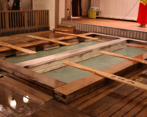 Traditional Japanese public bathhouses with wooden bathing pools filled with hot water.