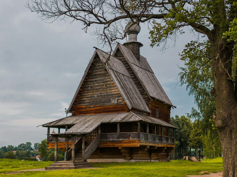 Traditional wooden architecture is raised above the ground, showing how elevated building forms can respond to landscape and environmental conditions.